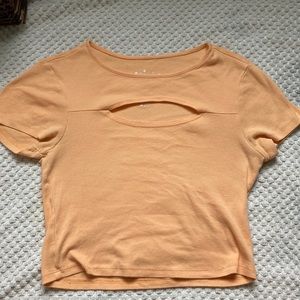 Pastel orange, crop top, with hole out for cleavage.